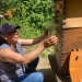 Elva Webster draws honey from a hive during a Spanish-language Master Beekeeping class.